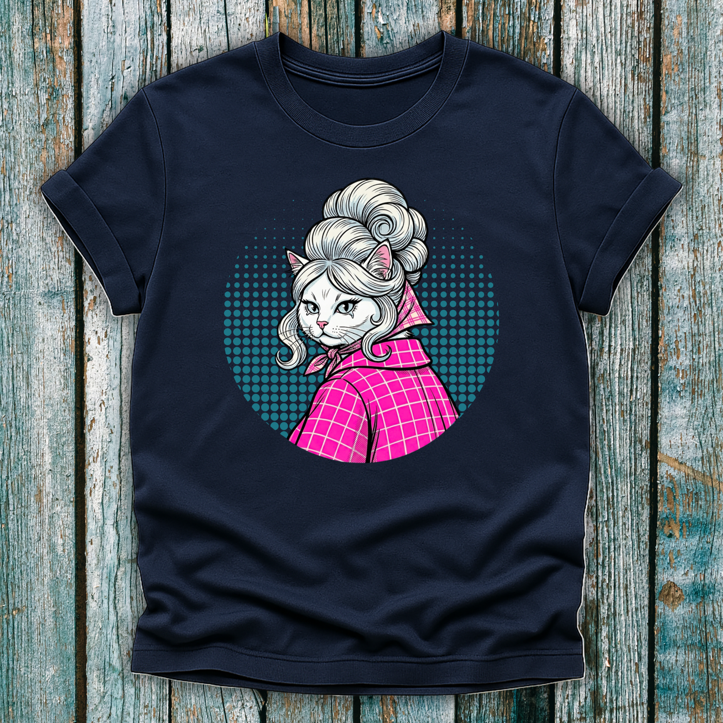 Navy  t-shirt with a colorful graphic of a pop art cat character in a pink outfit on a wooden surface