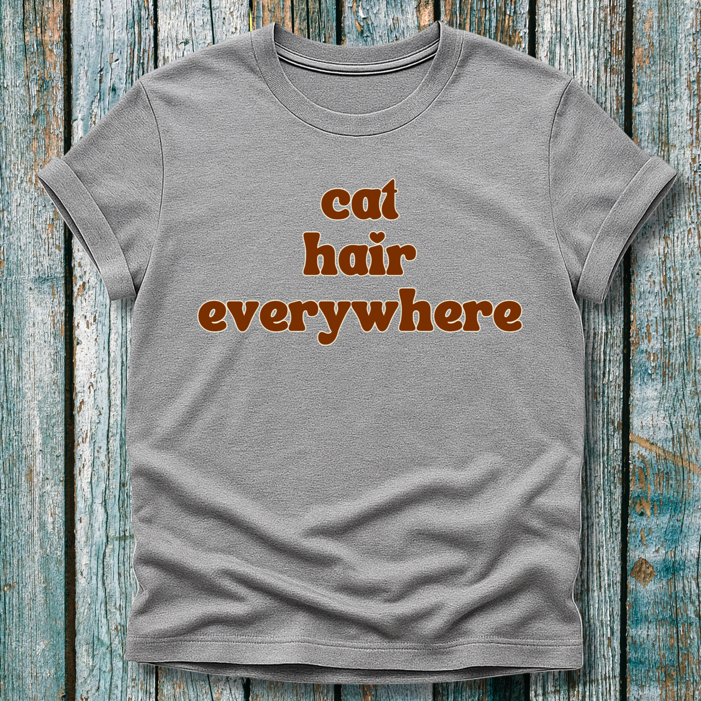 Gray t-shirt with 'cat hair everywhere' text on a wooden background