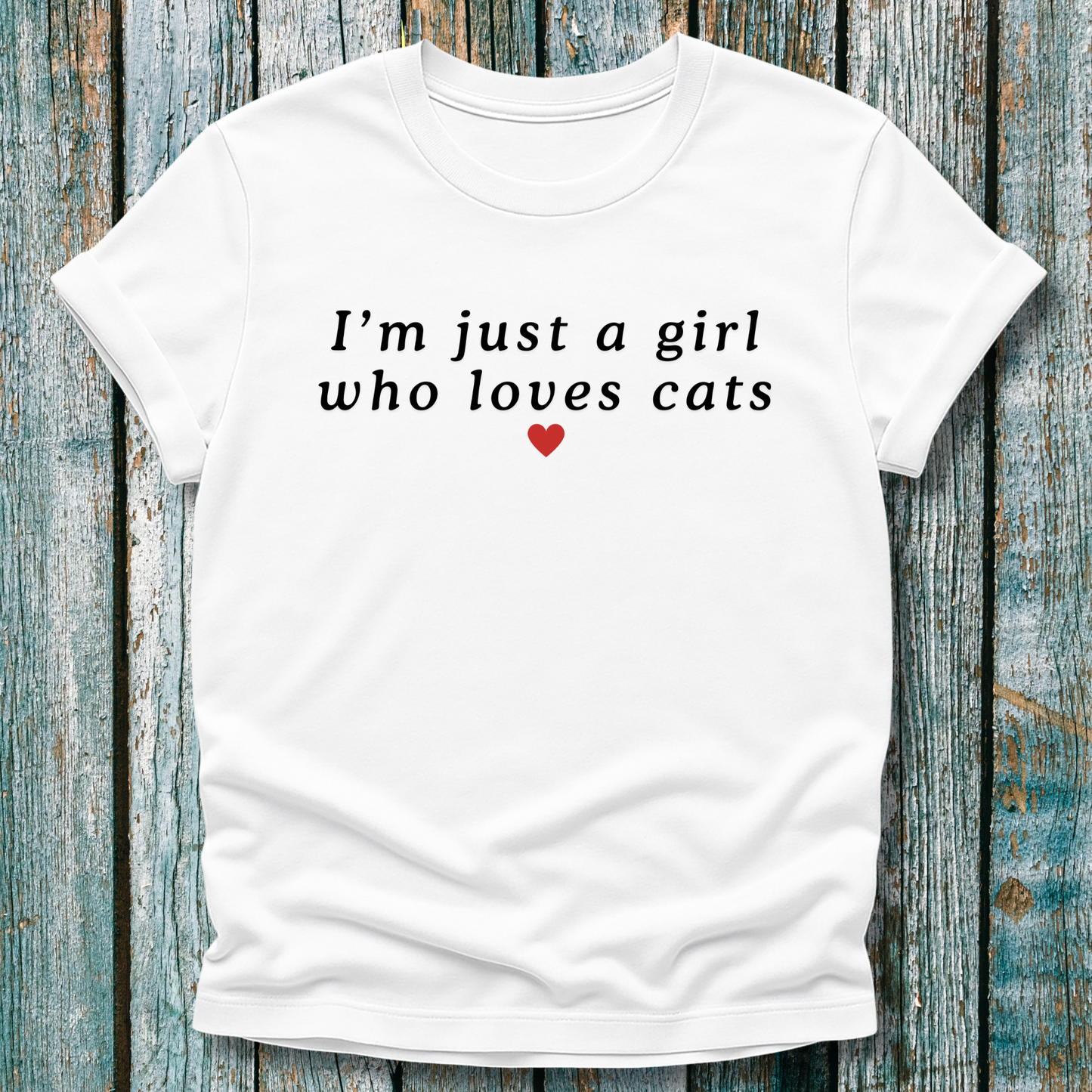 White t-shirt with 'I'm just a girl who loves cats' text on a wooden background