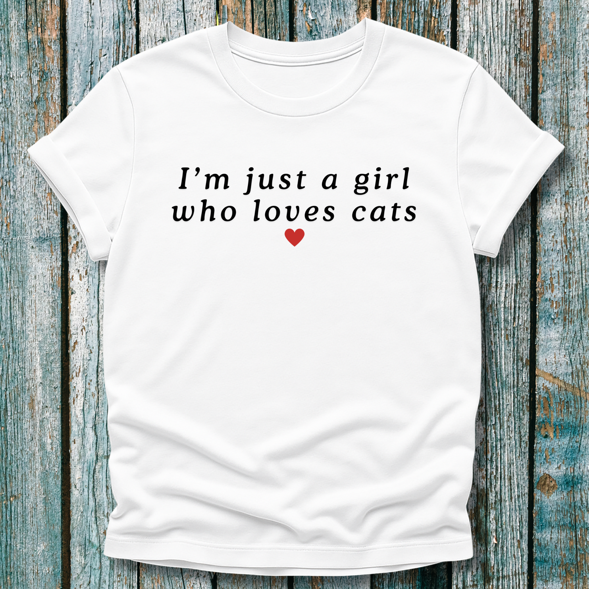 White t-shirt with 'I'm just a girl who loves cats' text on a wooden background