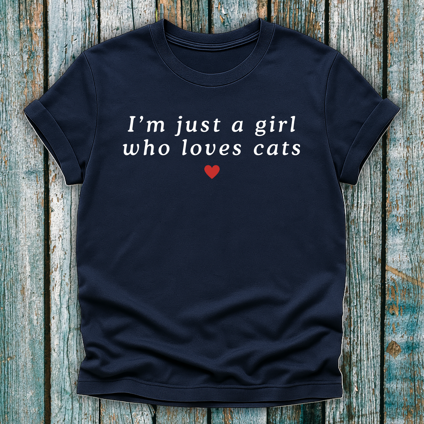 Navy blue t-shirt with text 'I'm just a girl who loves cats' on a wooden surface