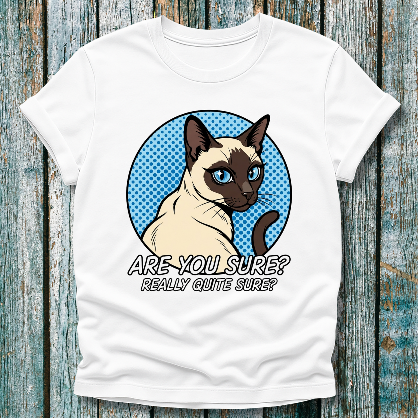 White t-shirt with a Siamese cat graphic and text on a wooden surface