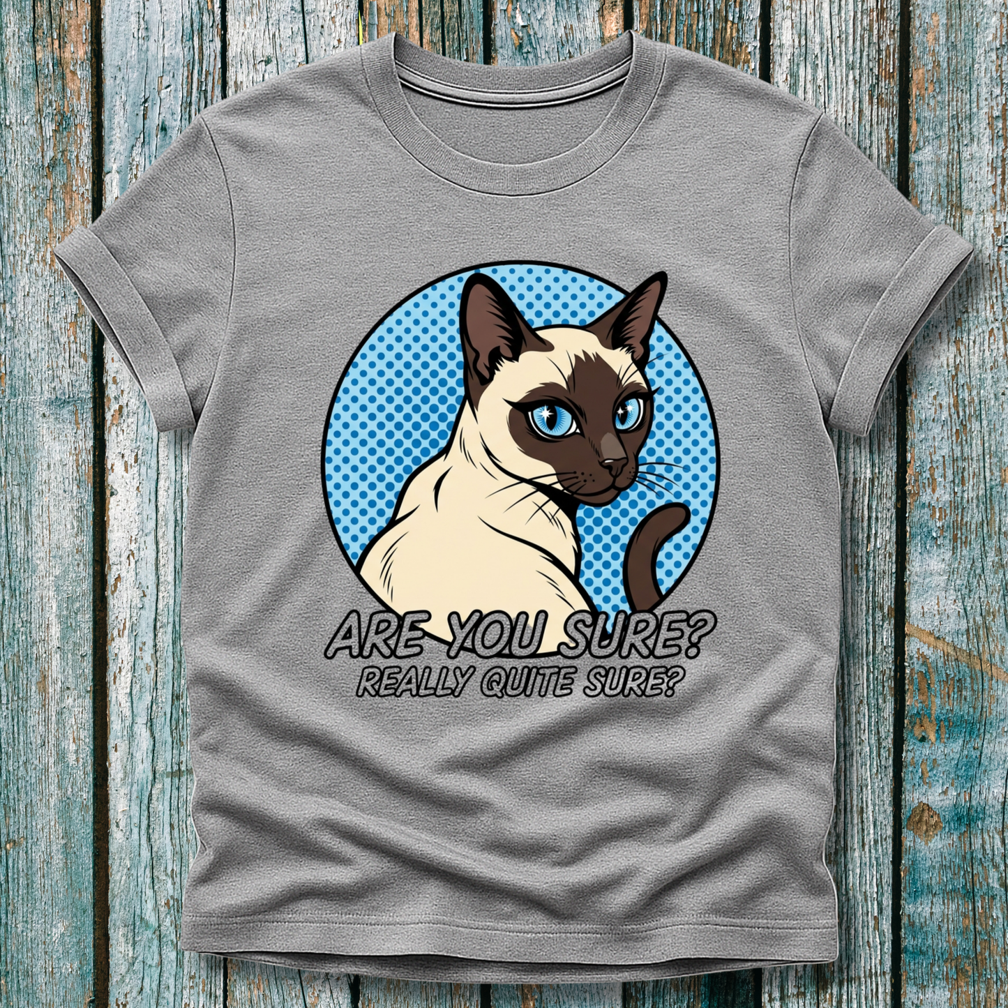 Gray t-shirt with a Siamese cat graphic and text on a wooden surface
