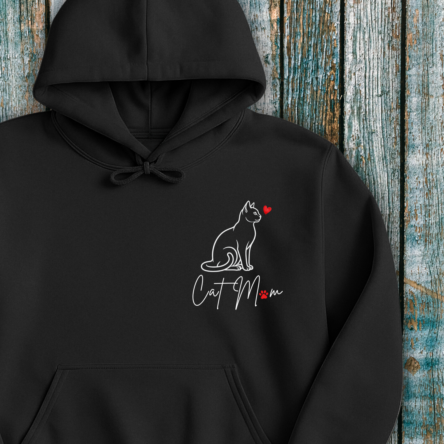 Black hoodie with 'Cat Mom' graphic and red heart on a wooden background