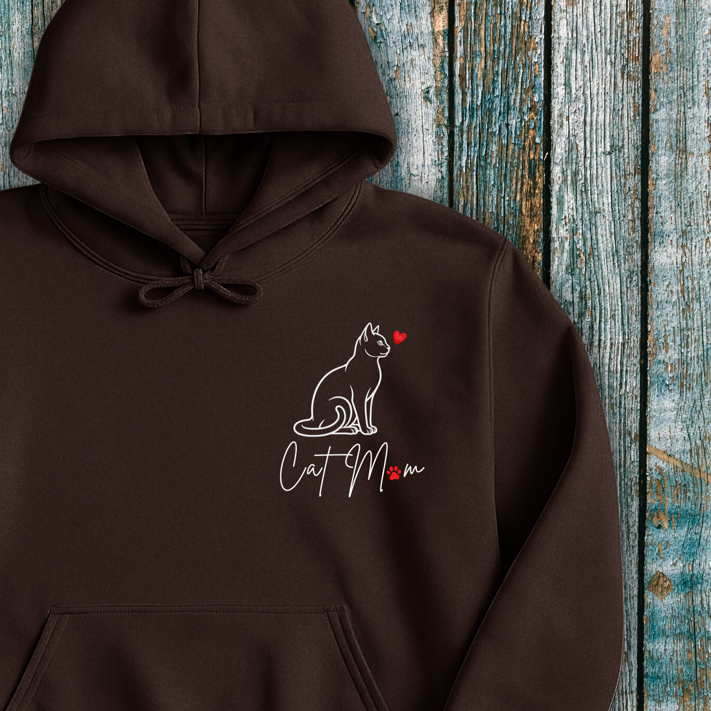 Brown hoodie with 'Cat Mom' graphic and red heart on a wooden background