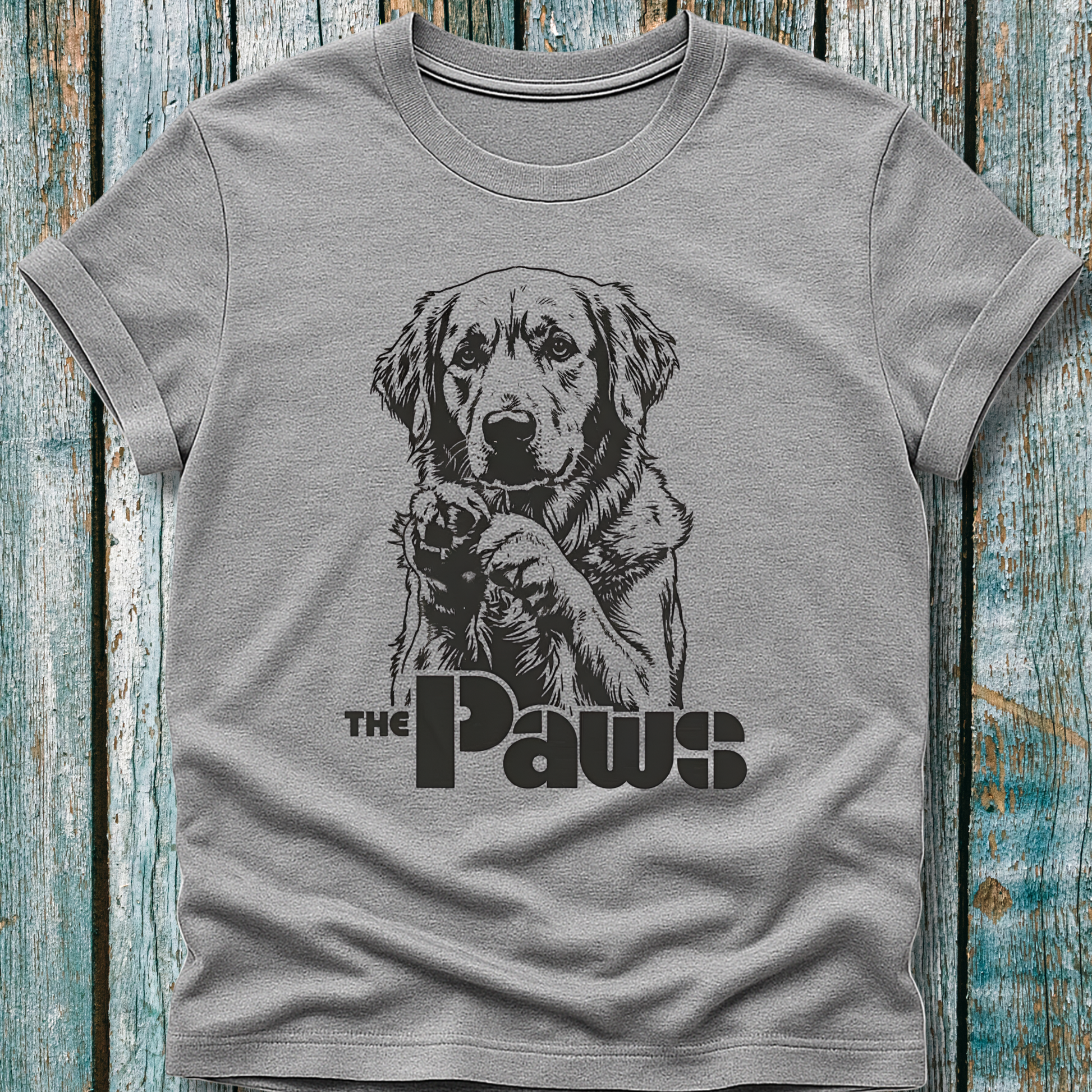 Gray t-shirt with a dog graphic and 'The Paws' text on a wooden surface