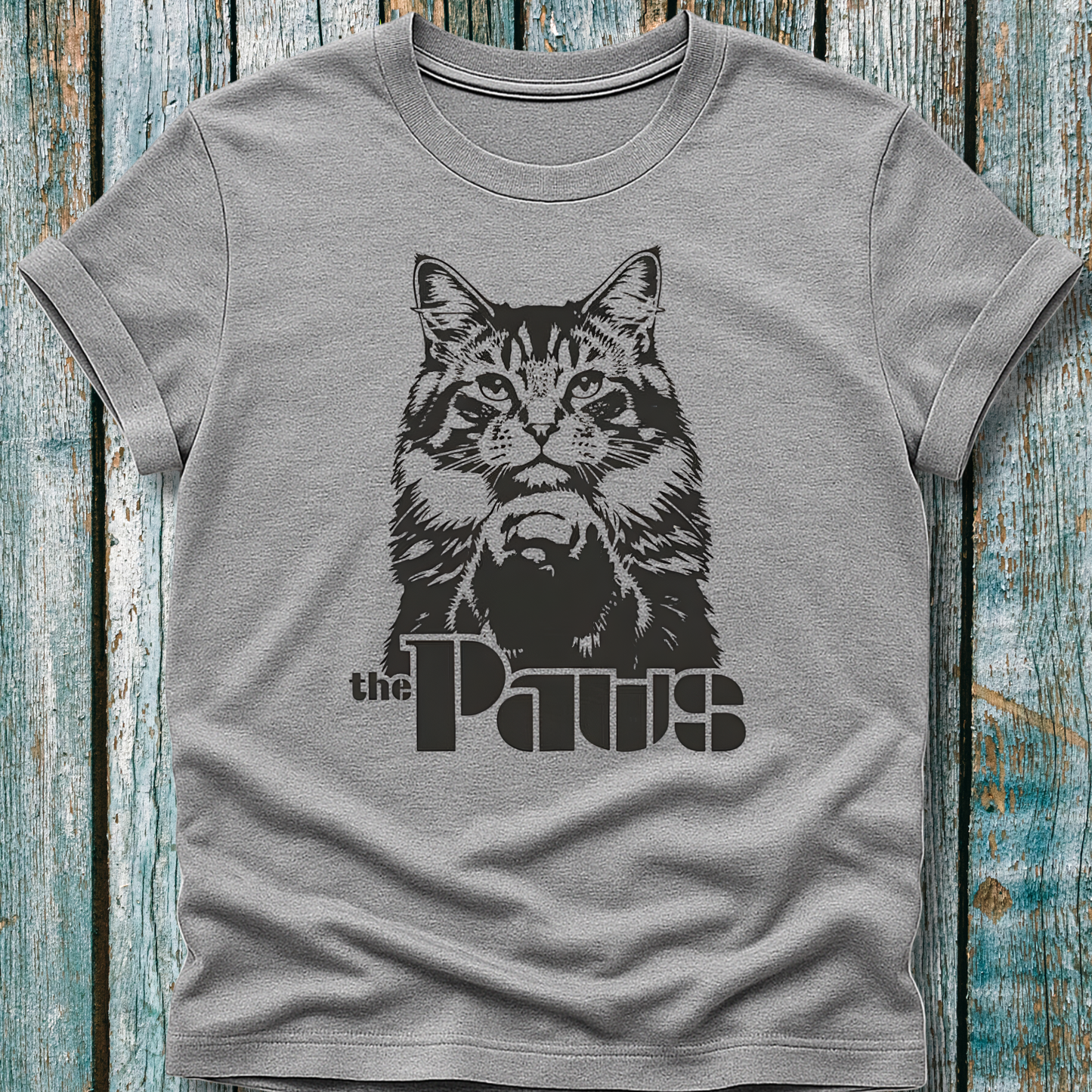 Gray t-shirt with a cat graphic and 'the Paws' text on a wooden surface