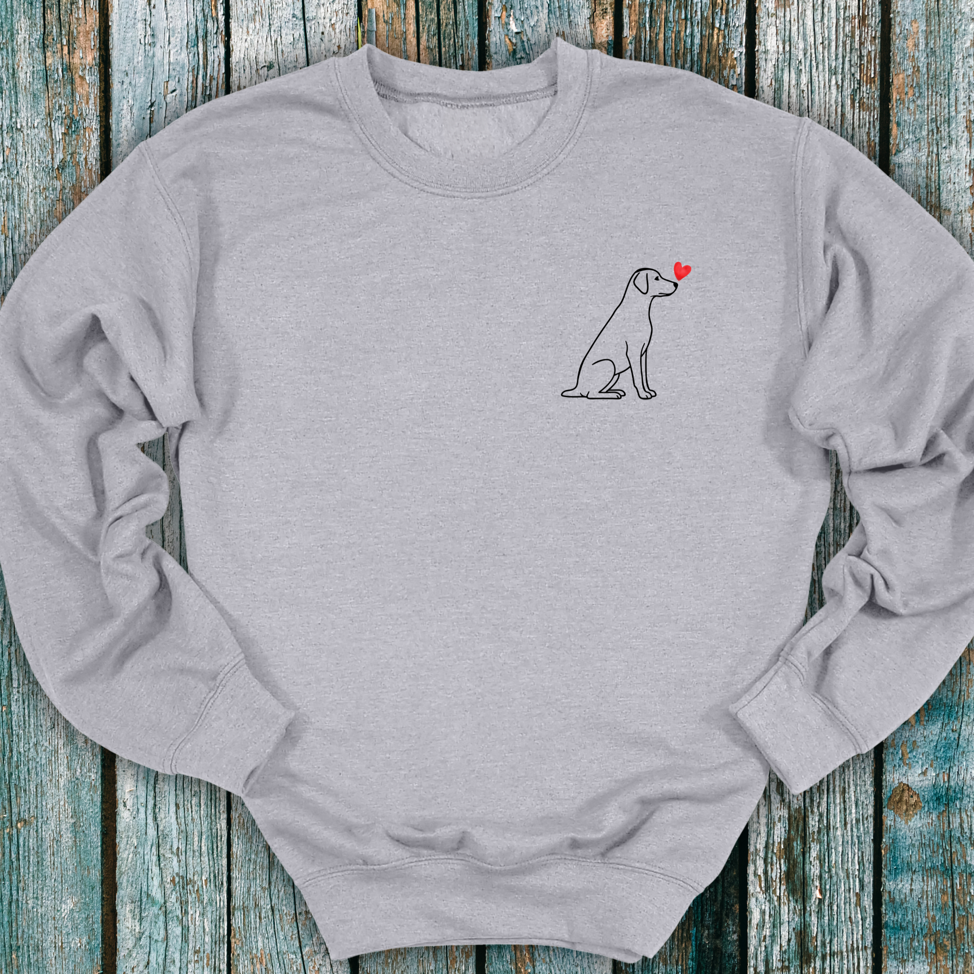Gray sweatshirt with a Labrador dog and heart design on a wooden surface