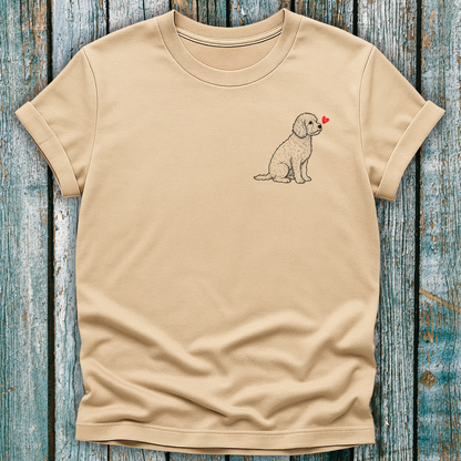 Beige t-shirt with a Cavapoo dog graphic and a red heart on a wooden surface