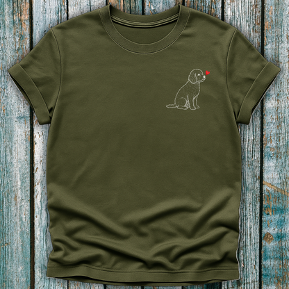 Green t-shirt with a Cavapoo dog graphic and a red heart on a wooden surface