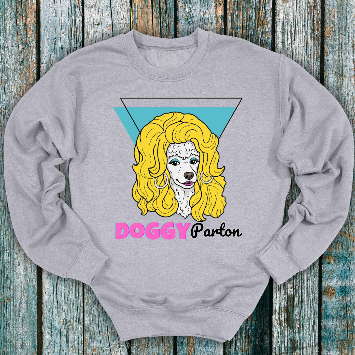 Gray sweatshirt with a graphic of a dog with blonde hair and 'Doggy Parton' text on a wooden background